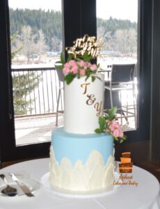 Two-tier wedding cake with blush pink roses at Calgary Waterfront Park Pavilion