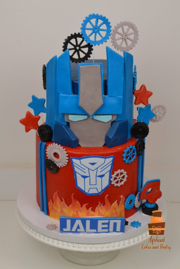 Transformers custom boy birthday cake with hand-sculpted edible robots and metallic fondant details made in Calgary by Afsheed Cakes.