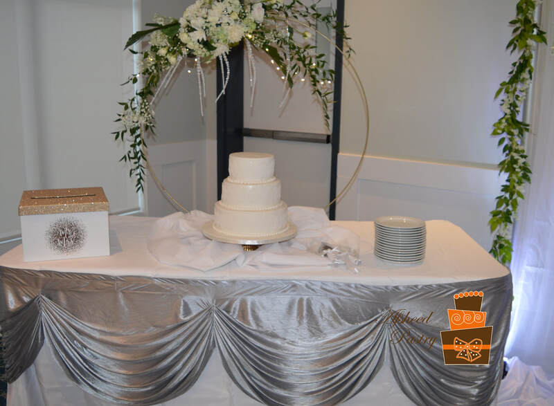 Custom lace wedding cakes Calgary - Three-tier white fondant wedding cake featuring delicate edible lace bands and pearl borders, delivered to Heritage Pointe Golf Club between Calgary and Okotoks by Afsheed cakes, in Calgary for couples seeking a timeless, elegant, and highest rated custom bakery for their luxury wedding.