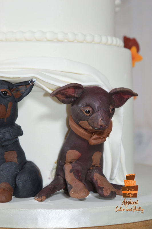 Two dogs being featured behind a wedding cake, hand made by Afsheed in Calgary