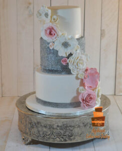 Majestic slick three tiered wedding cake decorated with hand made sugar flowers