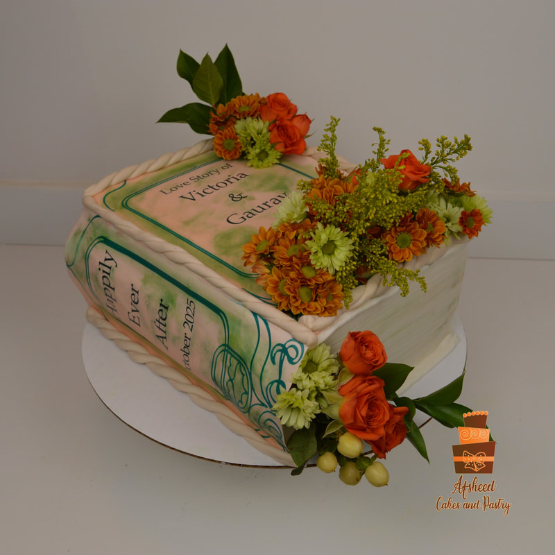 A personalized wedding cake with fresh flowers in shape of a book titled Happily ever after with the names of the bride and groom